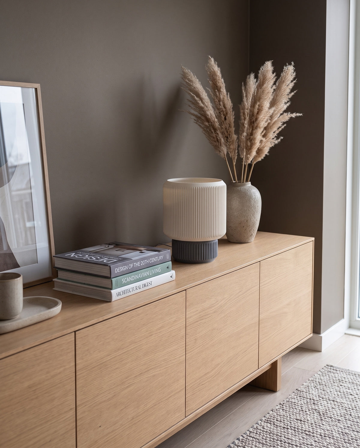Lámpara Ágora con base Gris sobre un mueble de madera clara