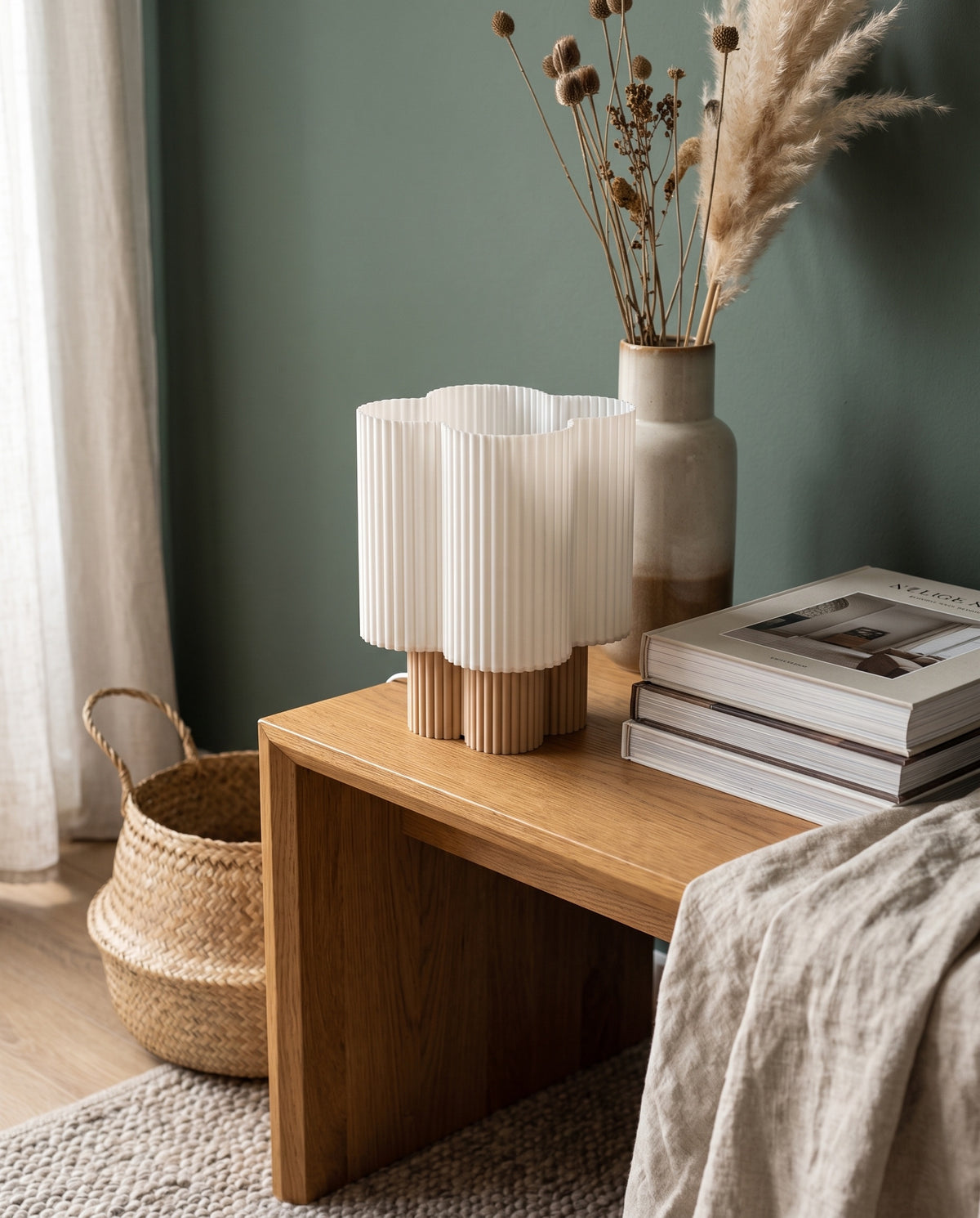 Lámpara Trébol con base Arena sobre una mesa de madera junto a una pared verde