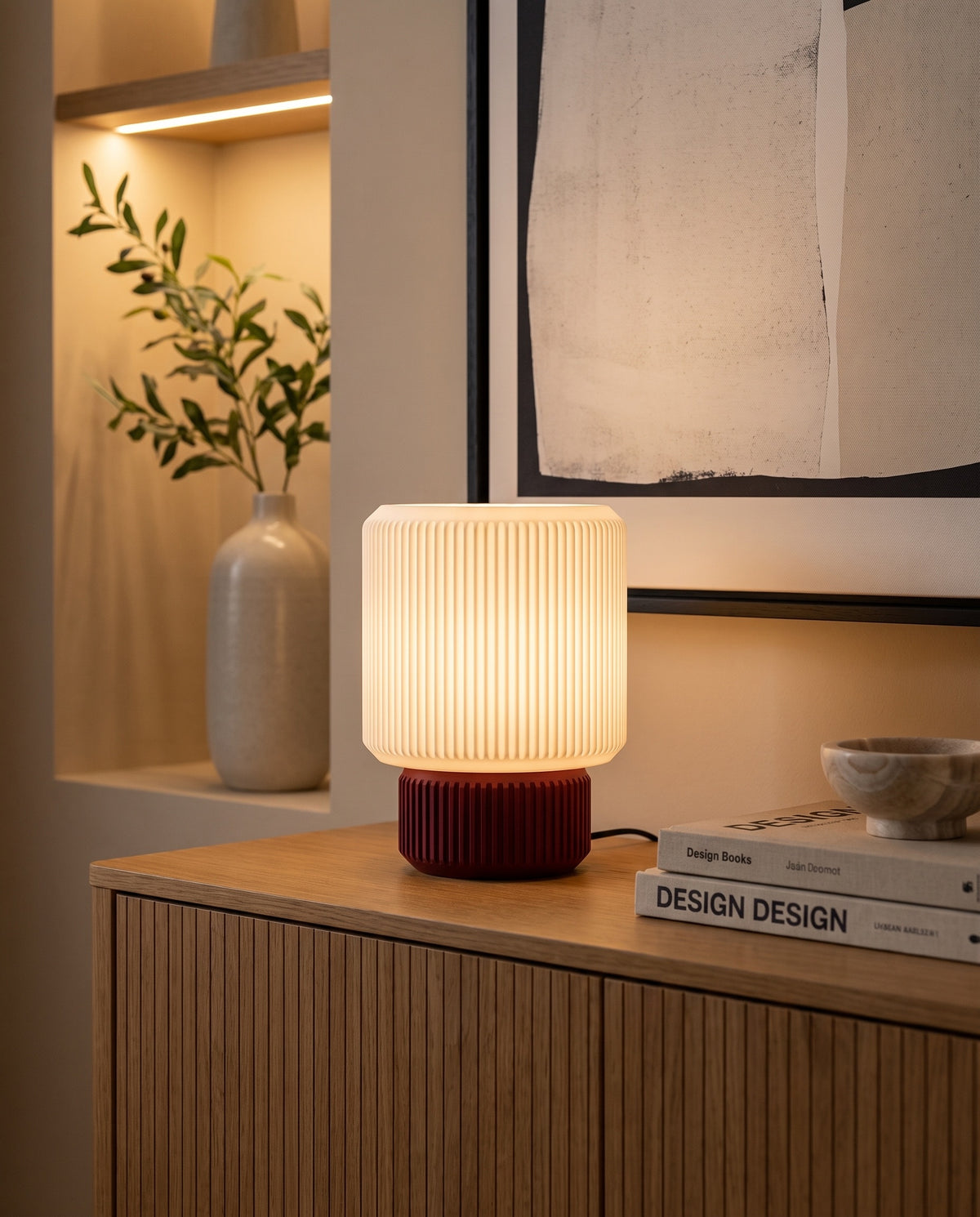 Lámpara Ágora con base Amarena, encendida sobre un aparador de madera