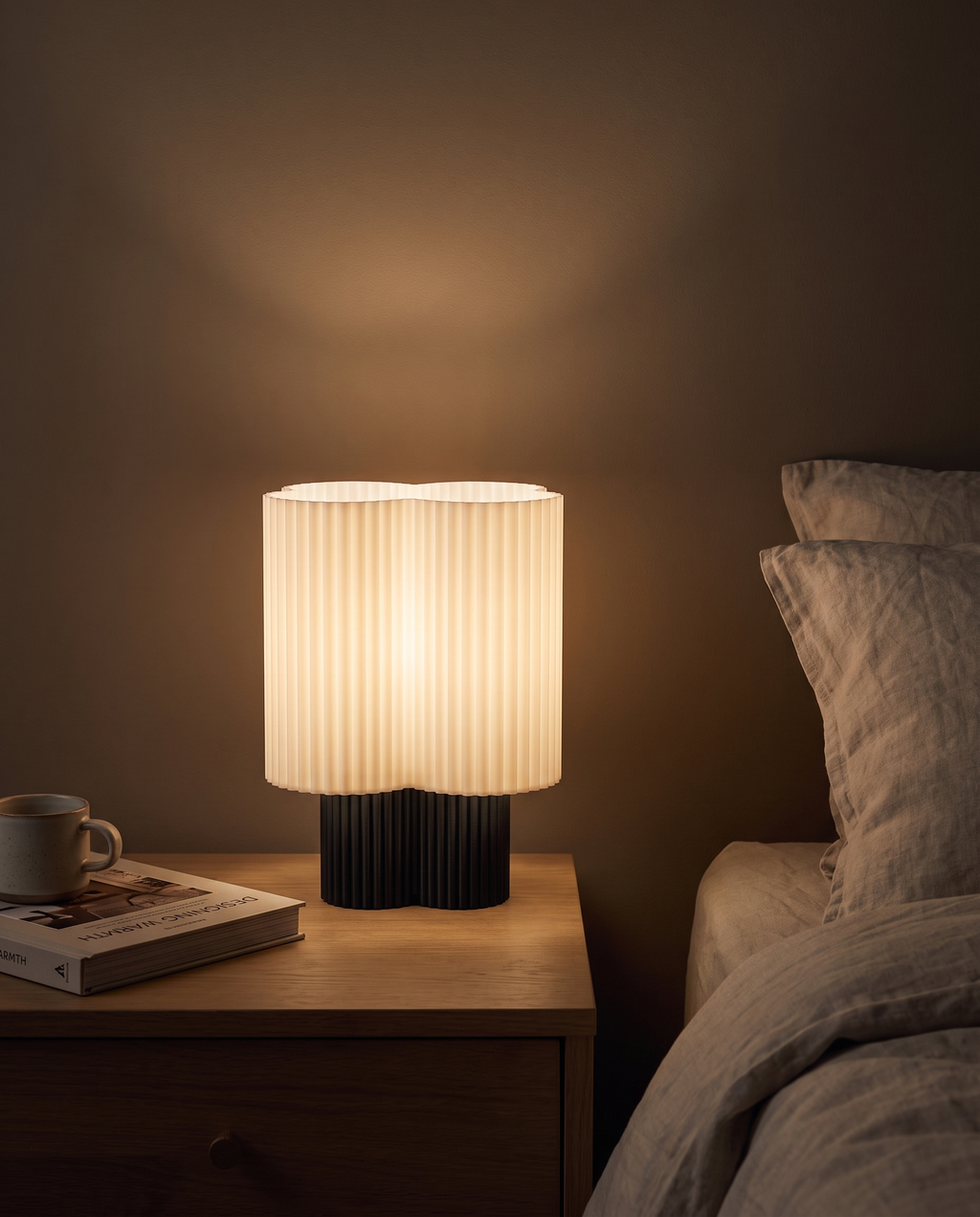 Lámpara Trébol encendida sobre una mesa de noche