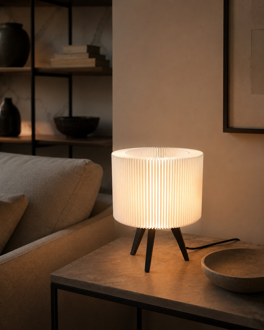 Lámpara Ópera en Blanco Algodón, encendida sobre una mesa junto al sofá
