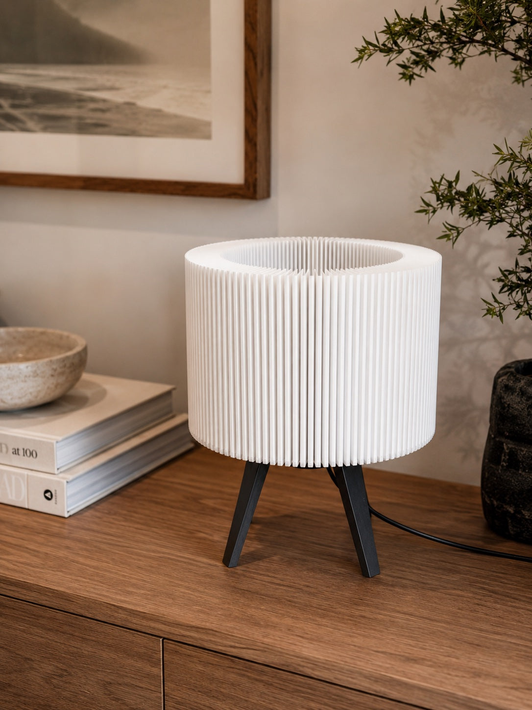 Lámpara Ópera en Blanco Algodón, apagada sobre un mueble de madera con libros