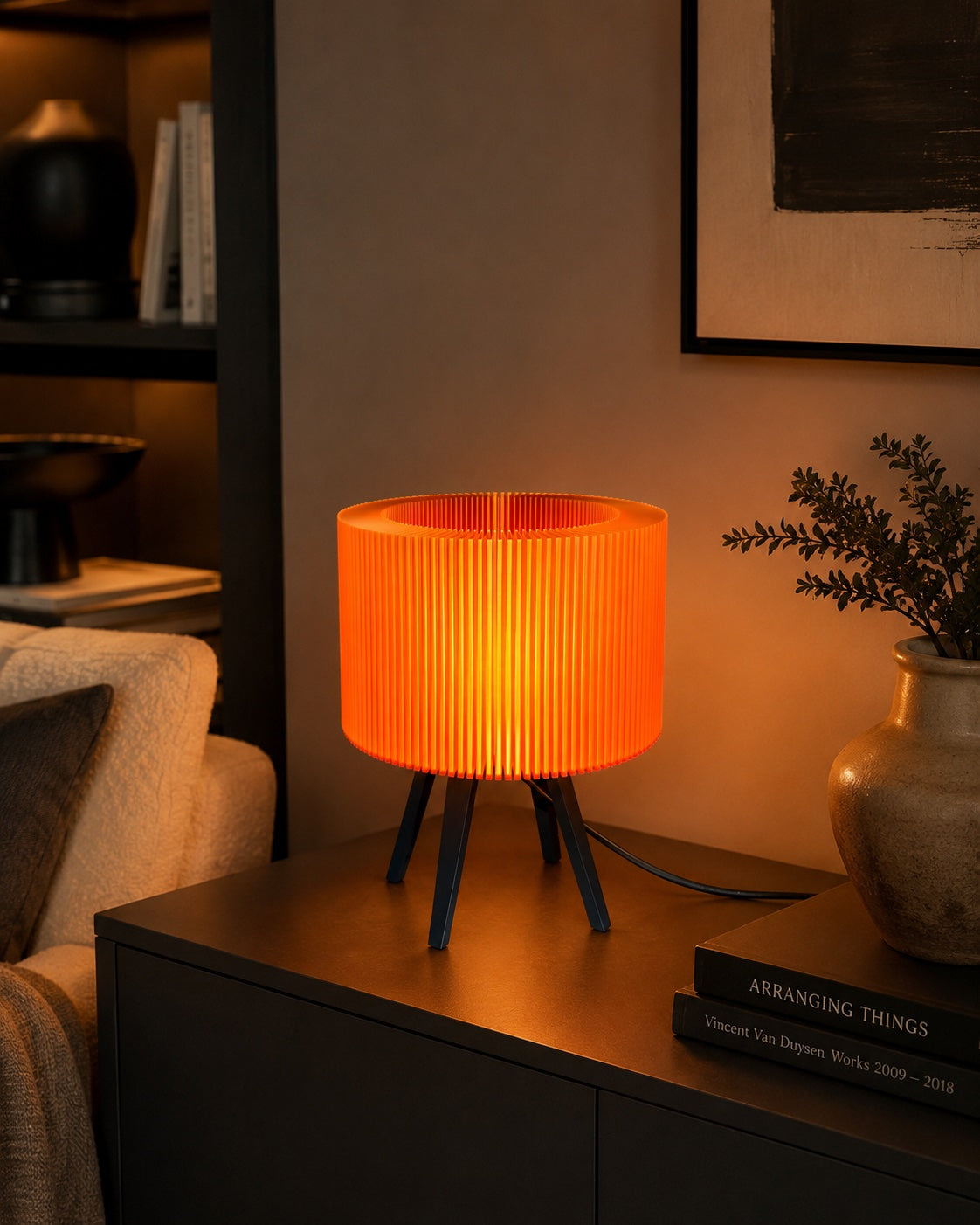 Lámpara Ópera en Caramelo Translúcido, encendida sobre un mueble junto al sofá